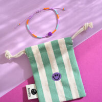 Perlenarmband smile lila/orange, mit Makrameeverschluss und Säckchen in grün/weiss