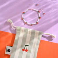 Perlenarmband Kirschen mit Makrameeverschluss, Säckchen hellgrün/natur und Kirsche gestickt